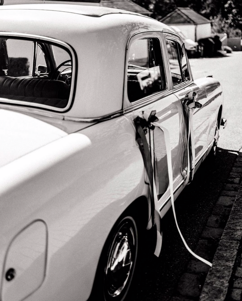 Classic vintage car exterior photographed in black and white showing sleek profile.