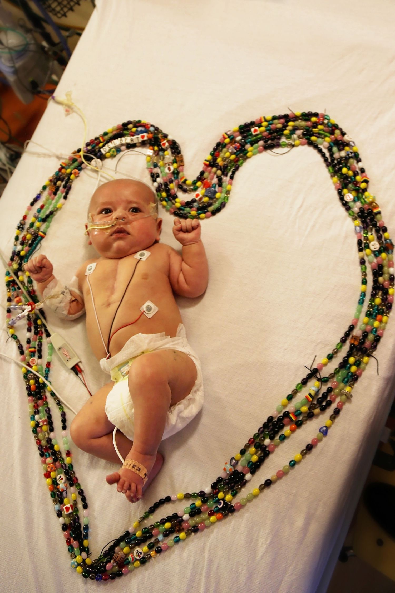 baby with all his beads of courage around him