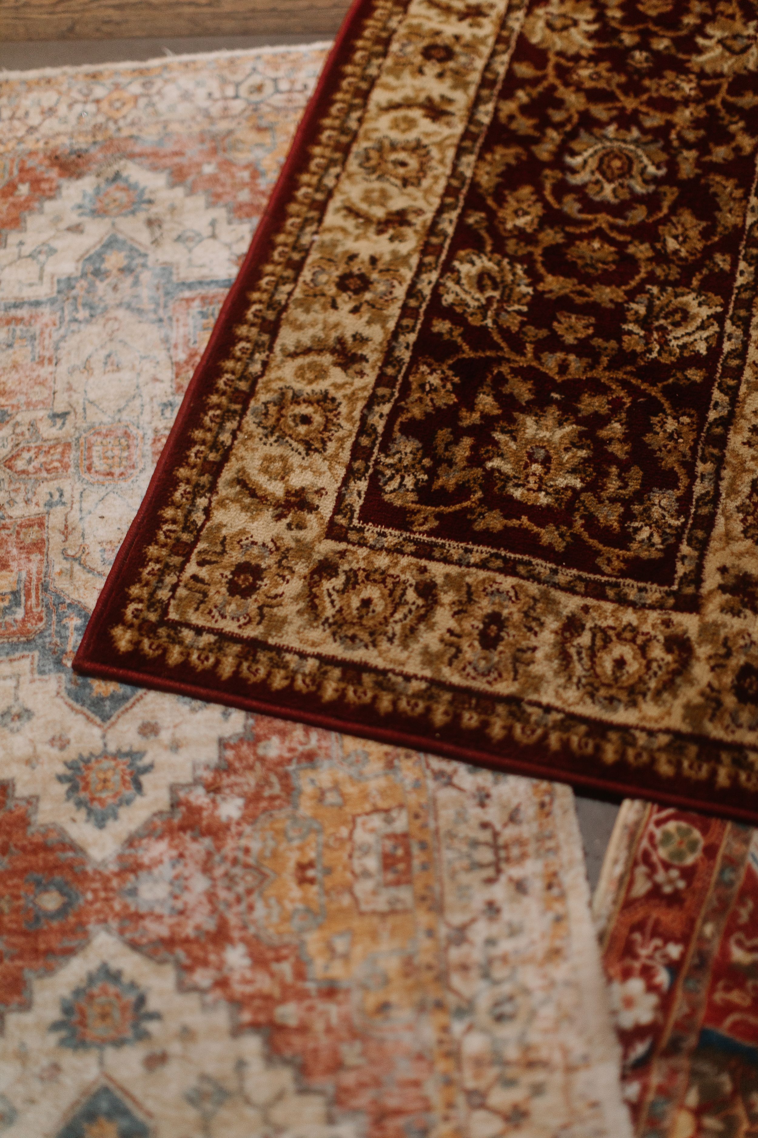 Two ornate Persian rugs with intricate floral patterns in rich red, cream, and blue tones.