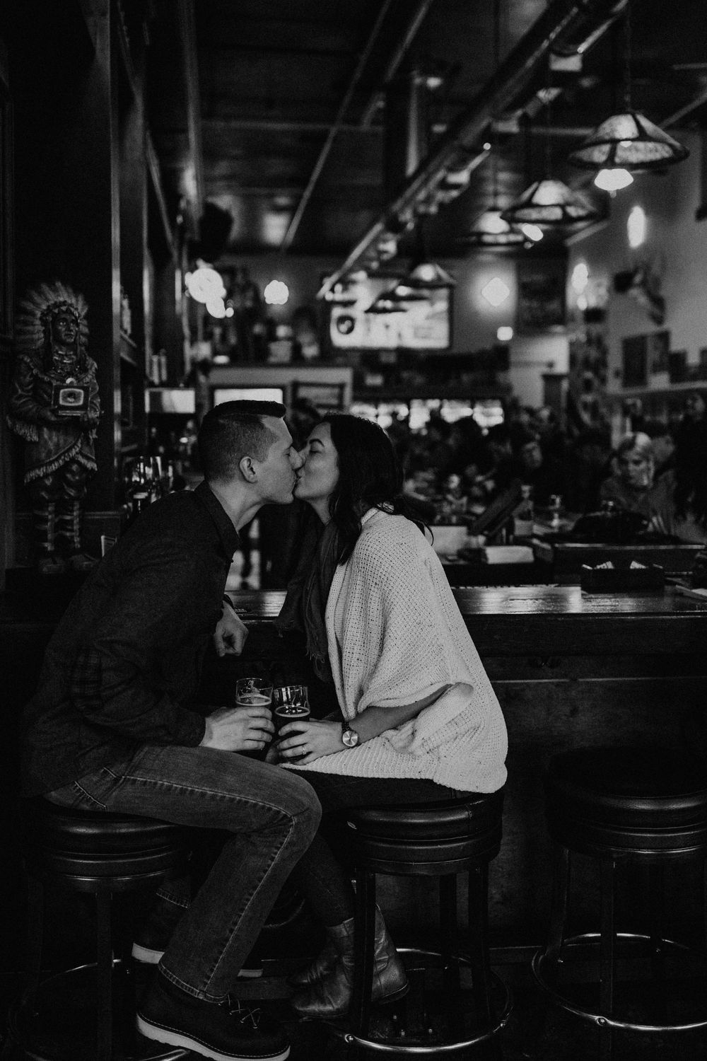 Romantic couple sharing an intimate moment at a dimly lit bar.