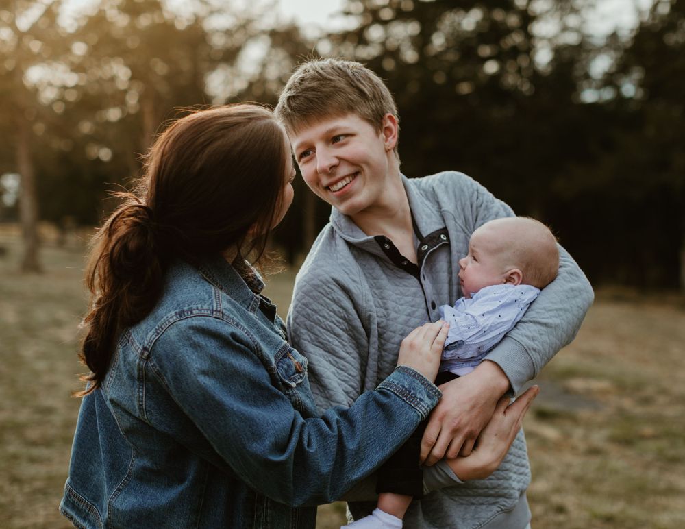 Family enjoying tender moments together during casual outdoor photo session.