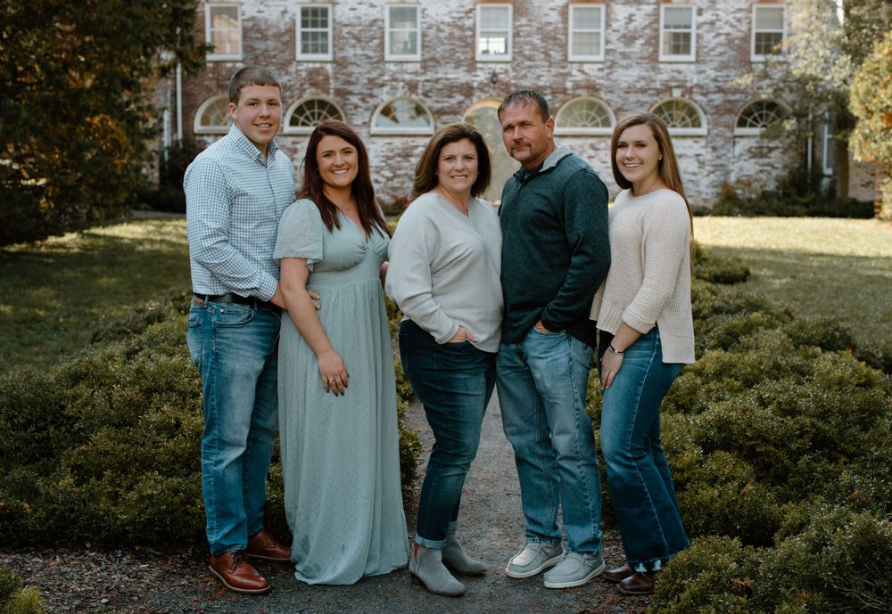 A family portrait session in front of a historic stone building.