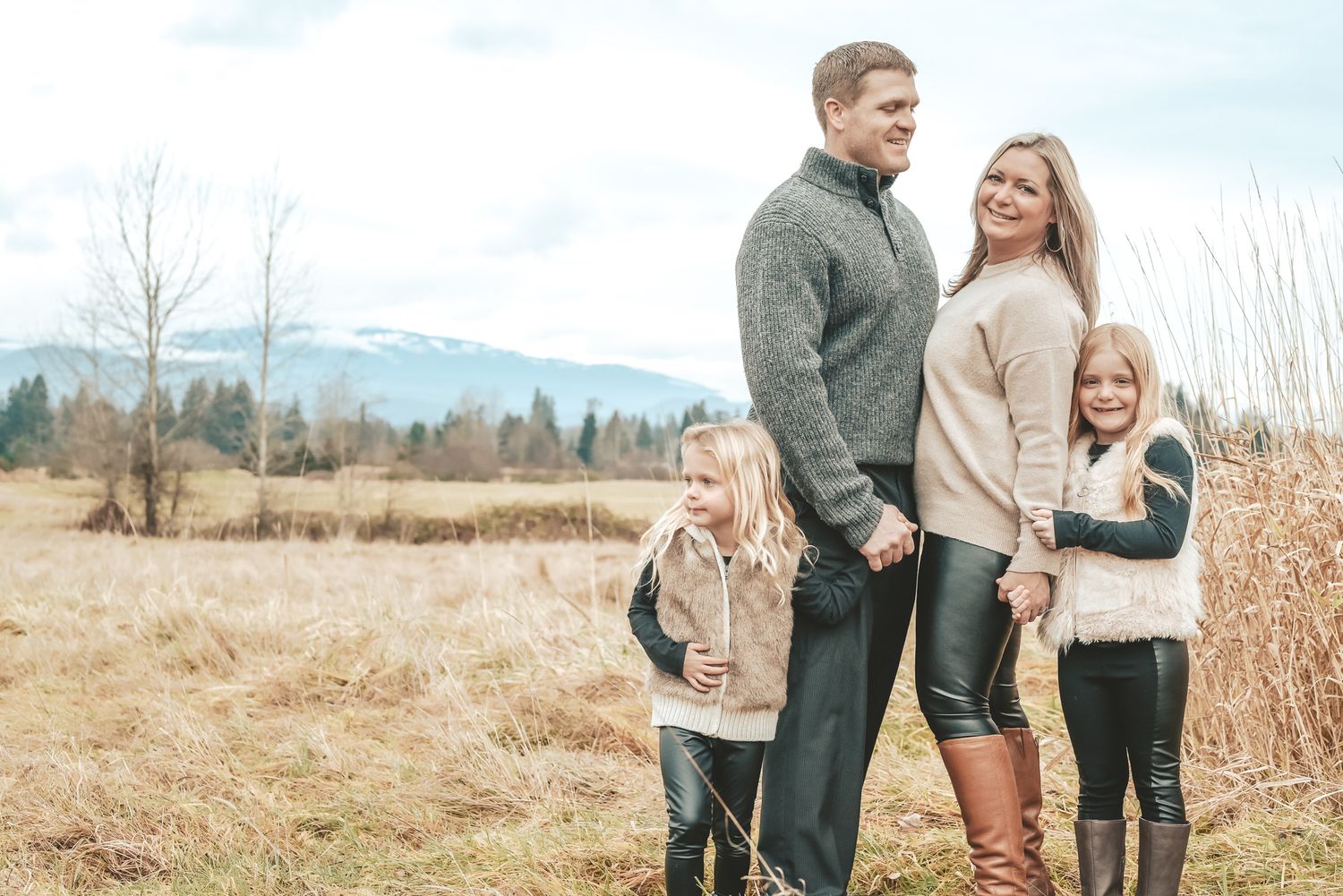 Photoshoot with couple and 2 young daughters in meadow.