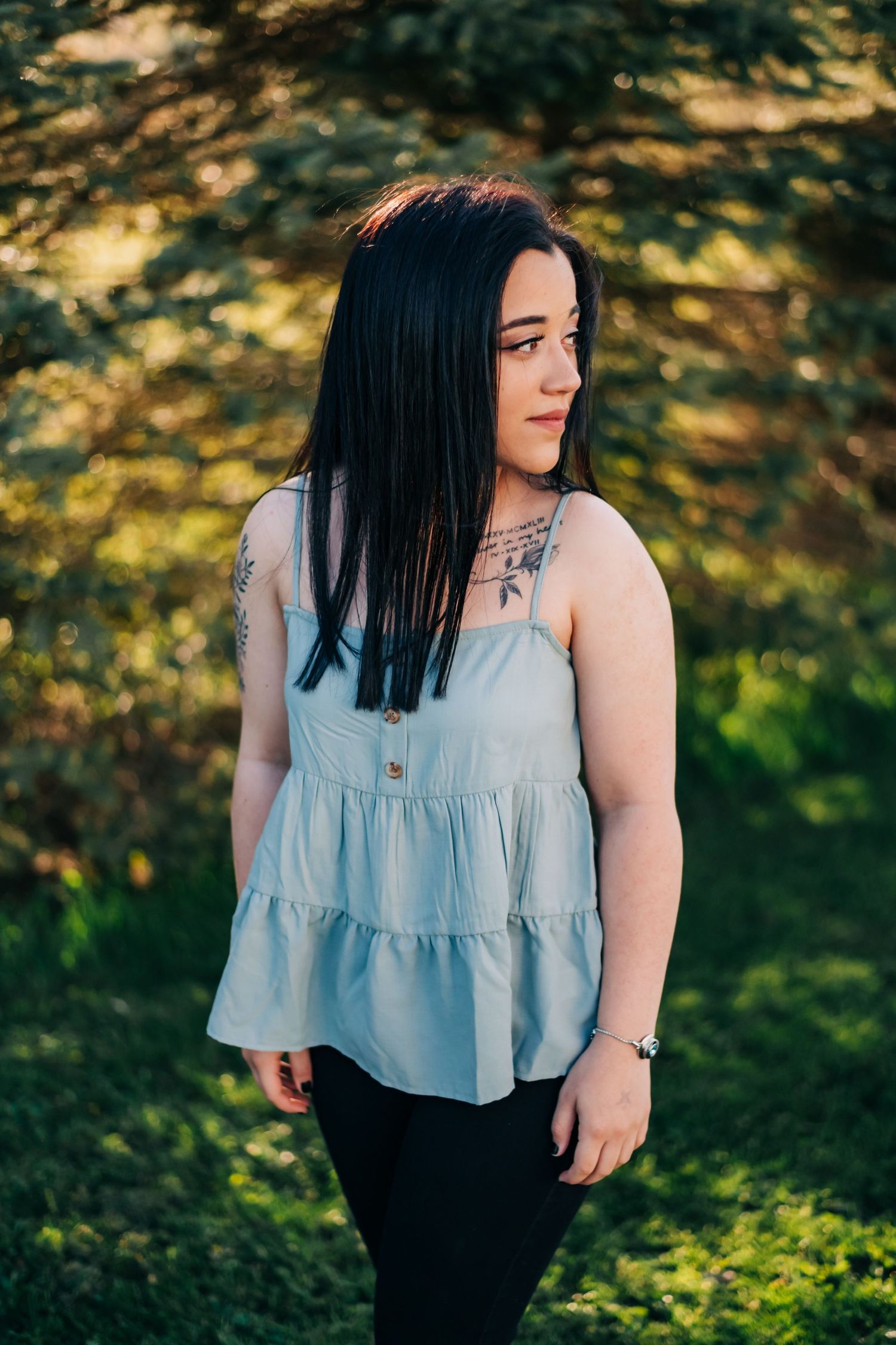 high school senior wearing a blue tank top looking over her shoulder