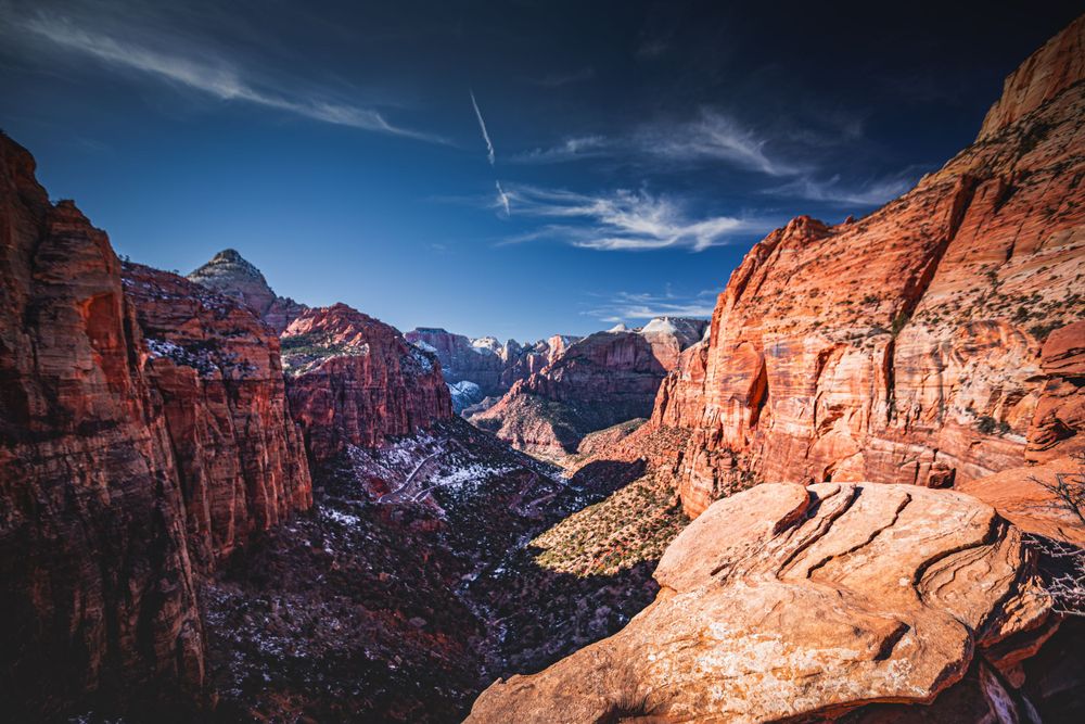 Sweeping vista of red rock canyons and cliffs in Zion National Park under blue skies.
