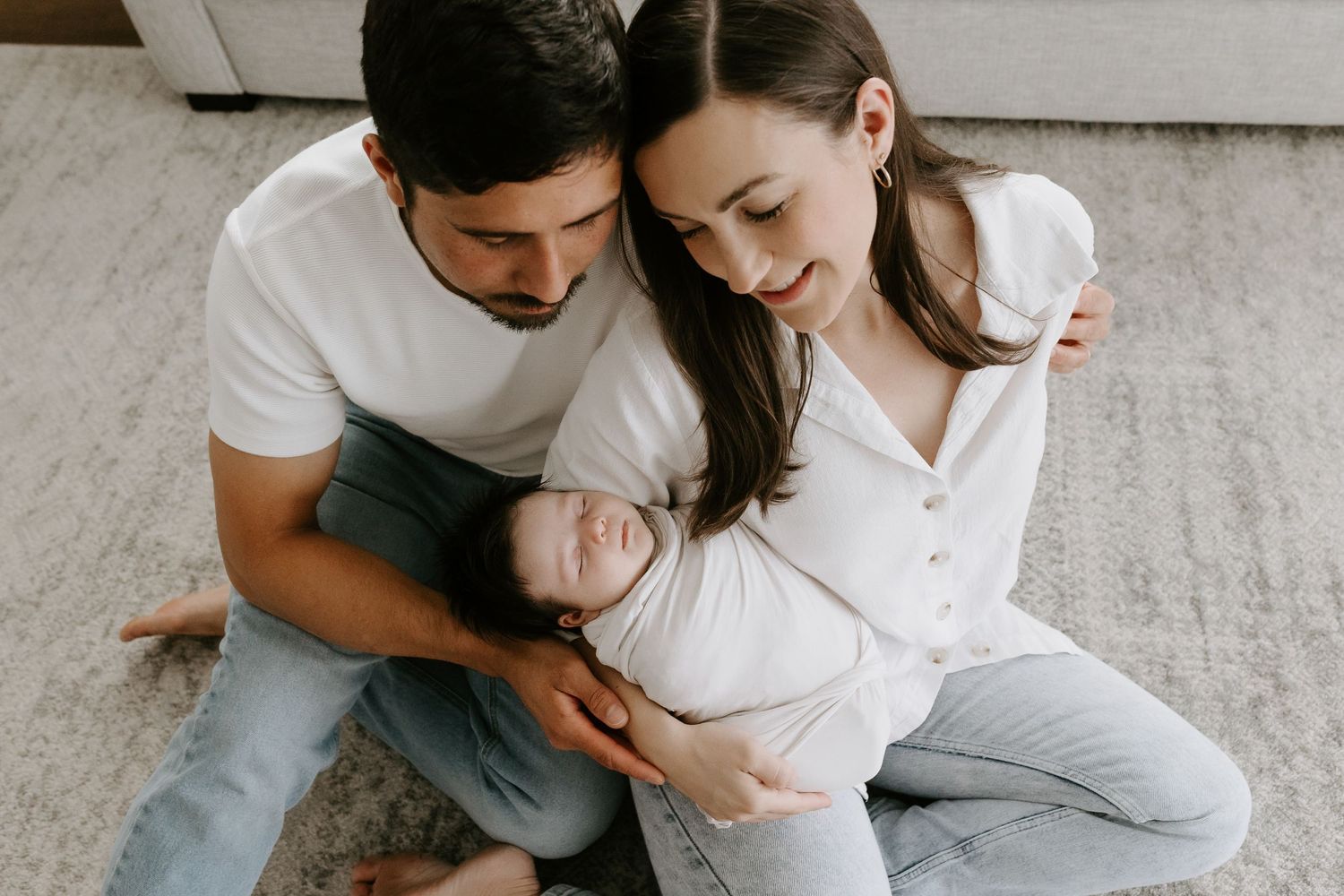 Tender moment between parent and infant in soft natural light.
