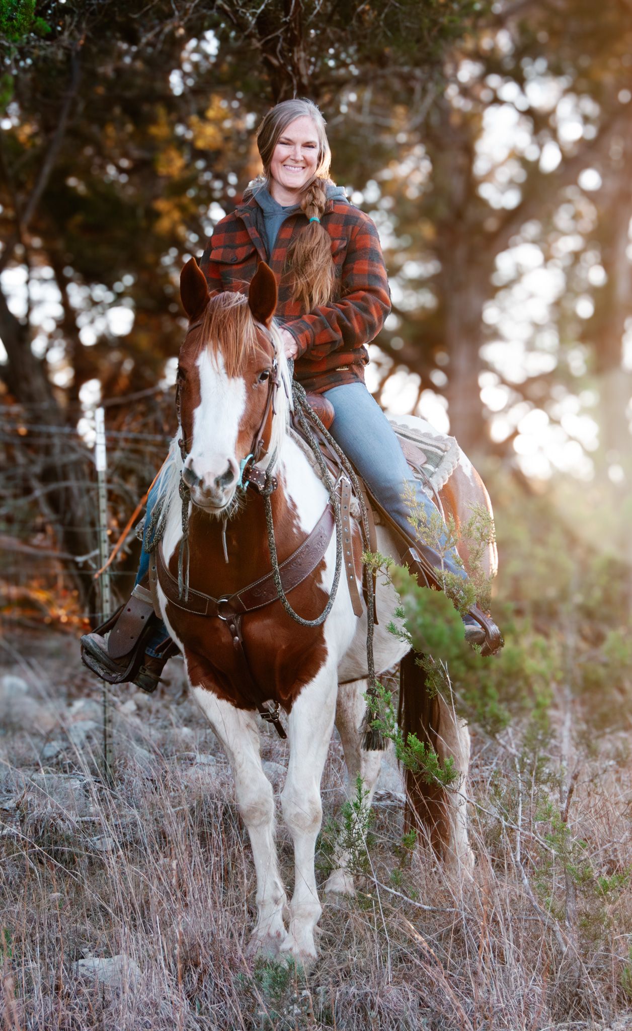 Cowgirl riding her paint horse at golden hour during an equine photography session in the Texas Hill Country