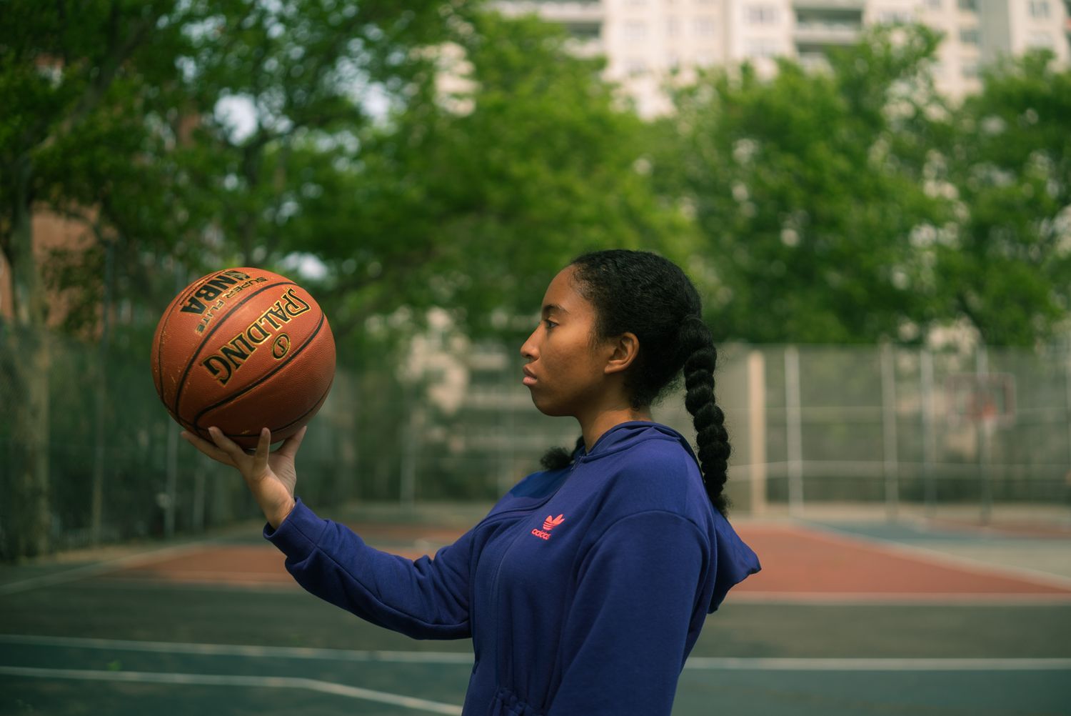 Basketball player practices shooting drills on an outdoor court.