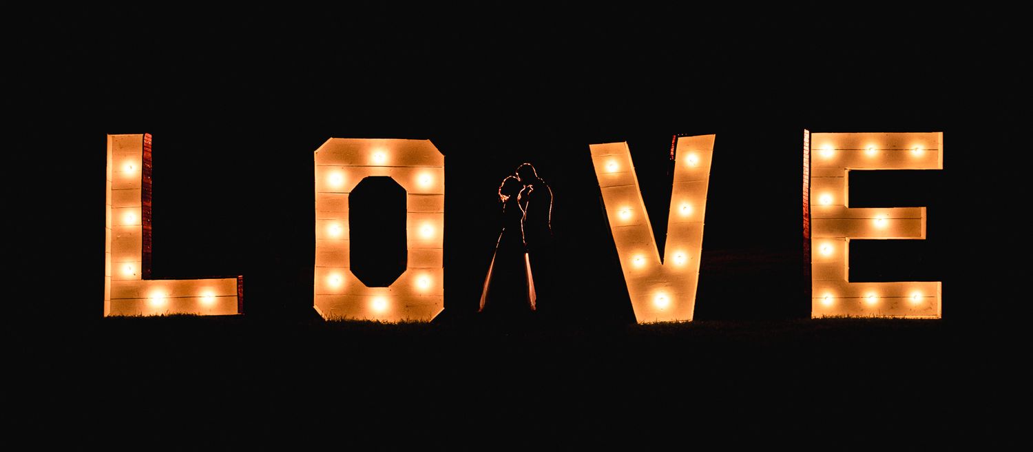 Illuminated marquee letters spelling out LOVE against dark background.