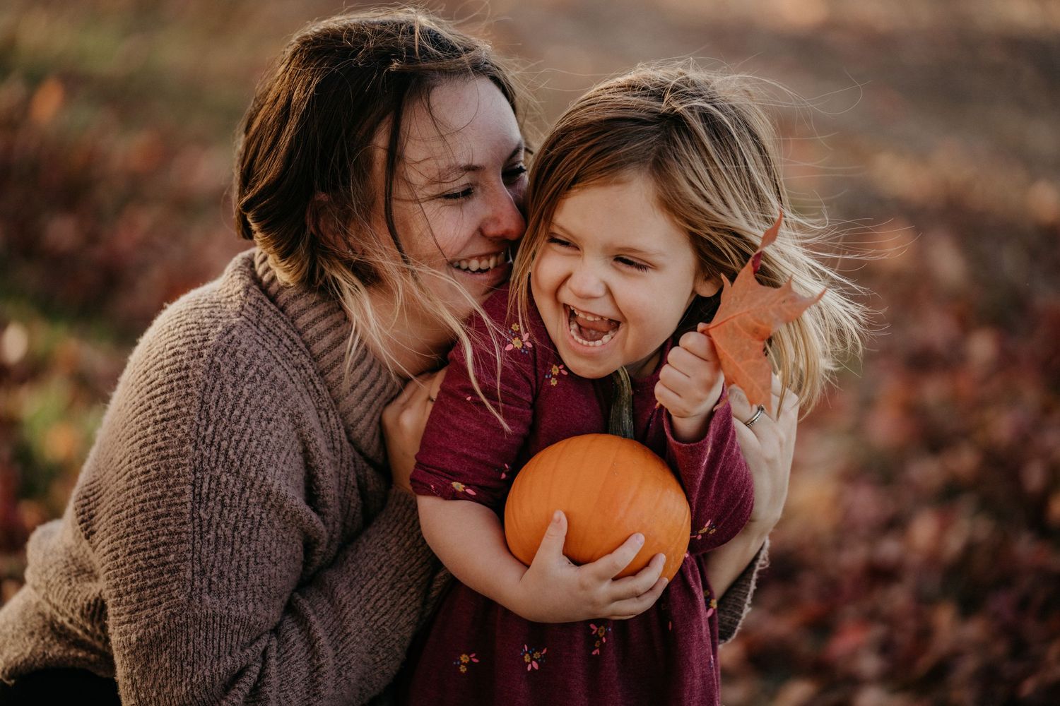 A joyful autumn moment with a pumpkin against a background of fall foliage.
