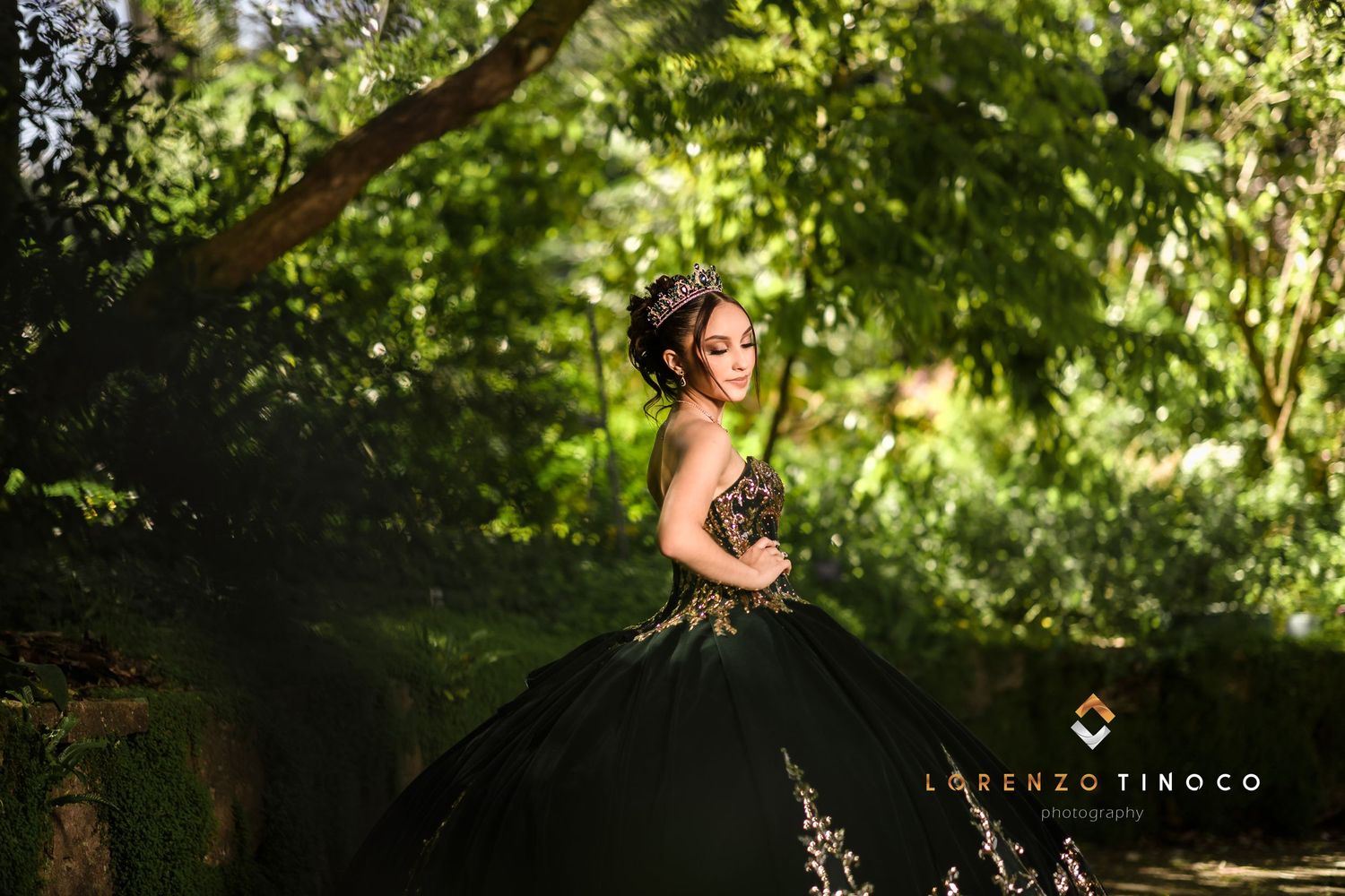 Elegant black ball gown with gold embellishments captured in a lush garden setting.