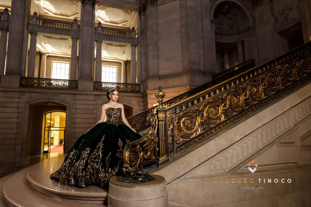Dramatic black ball gown photographed on ornate grand staircase in classical building.