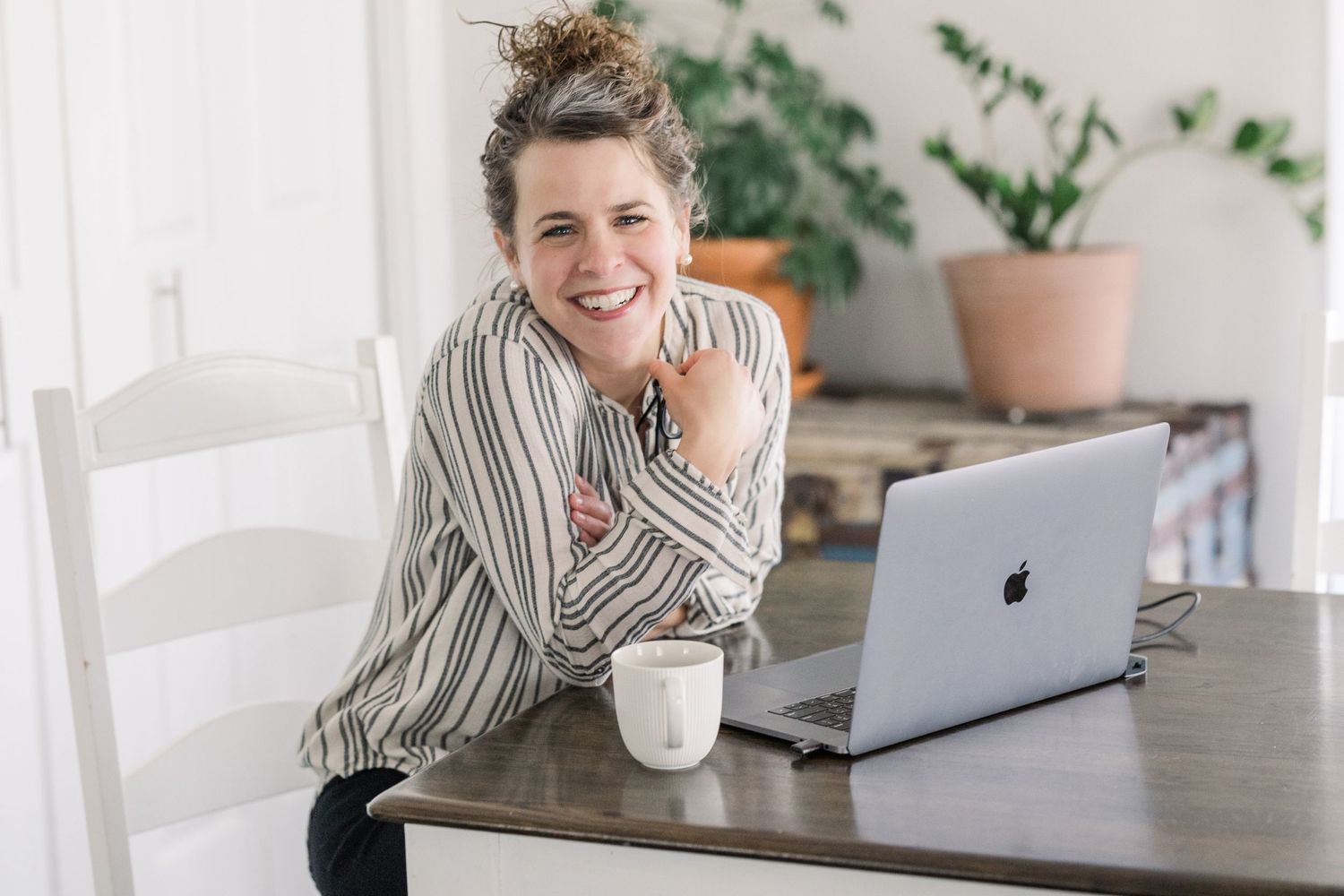 A casual workspace scene with a laptop and coffee cup on a wooden table.