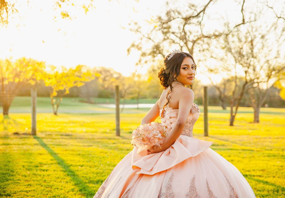Sunset photoshoot in a field showing flowing pink dress movements against golden light.