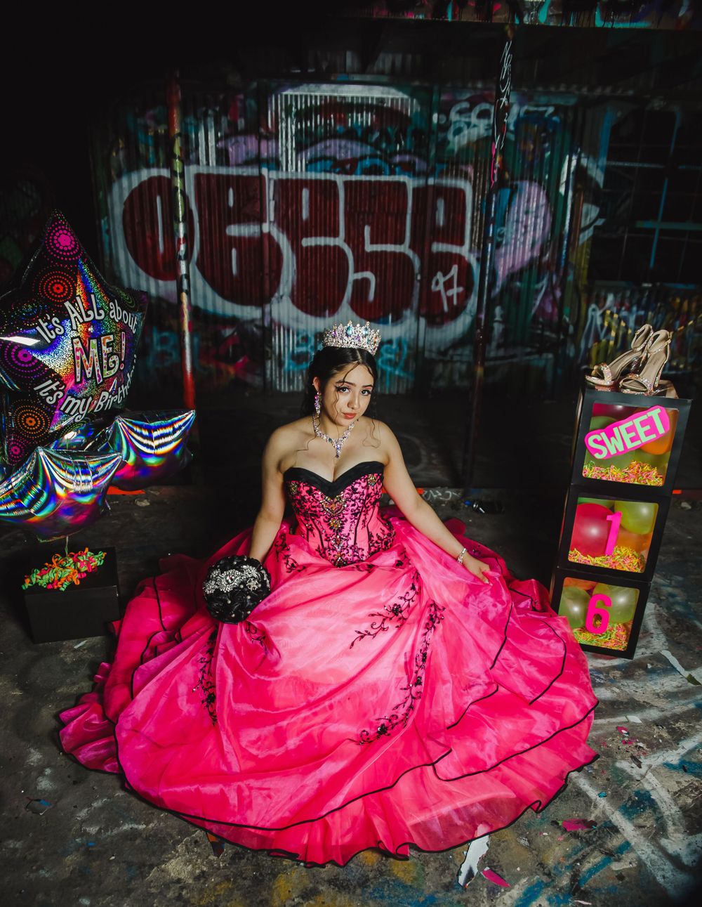 A vibrant pink ball gown contrasts against urban graffiti walls in an edgy photo shoot.