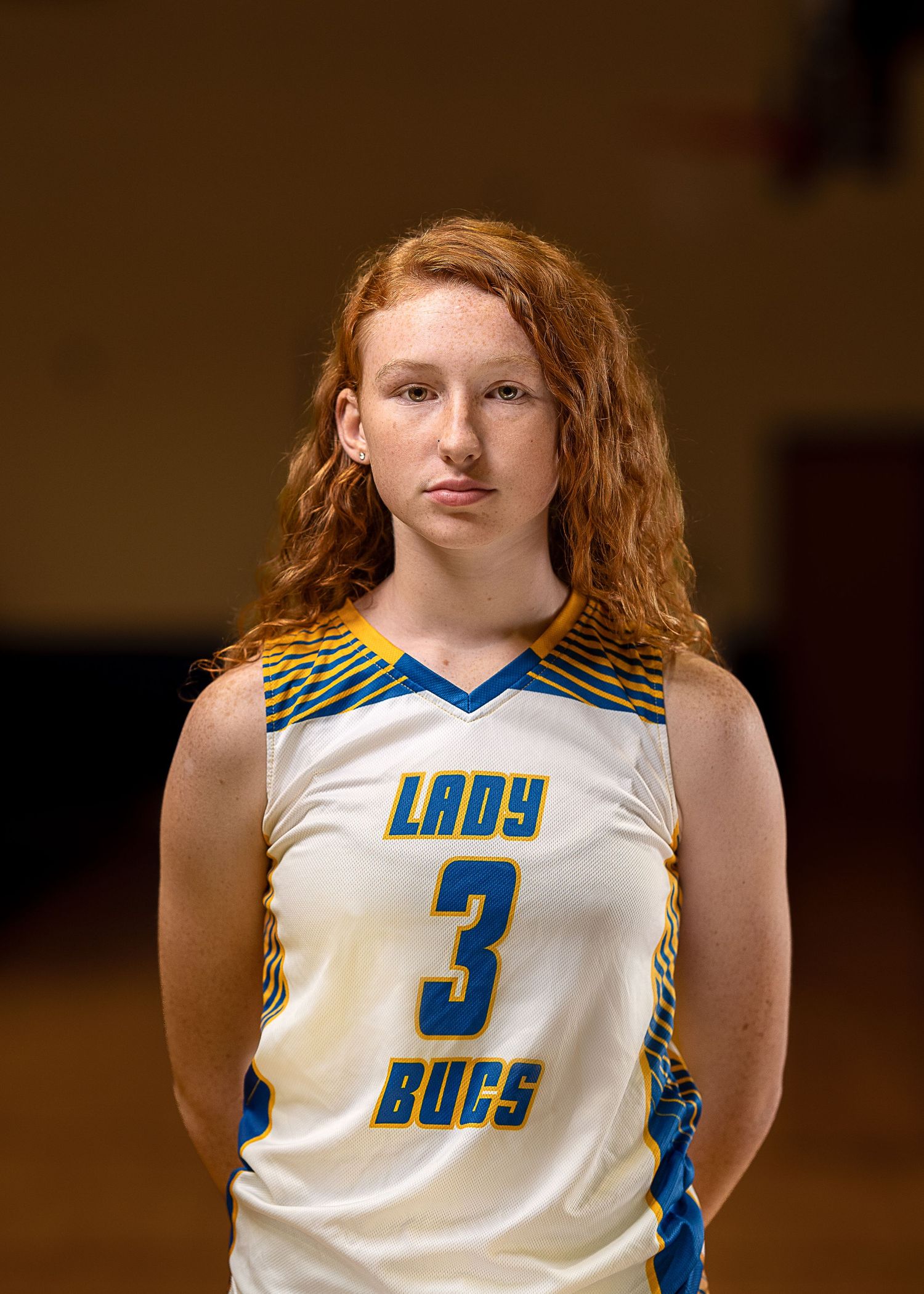 Basketball player wearing a white Lady Bucs jersey with number 3 poses for a team photo.