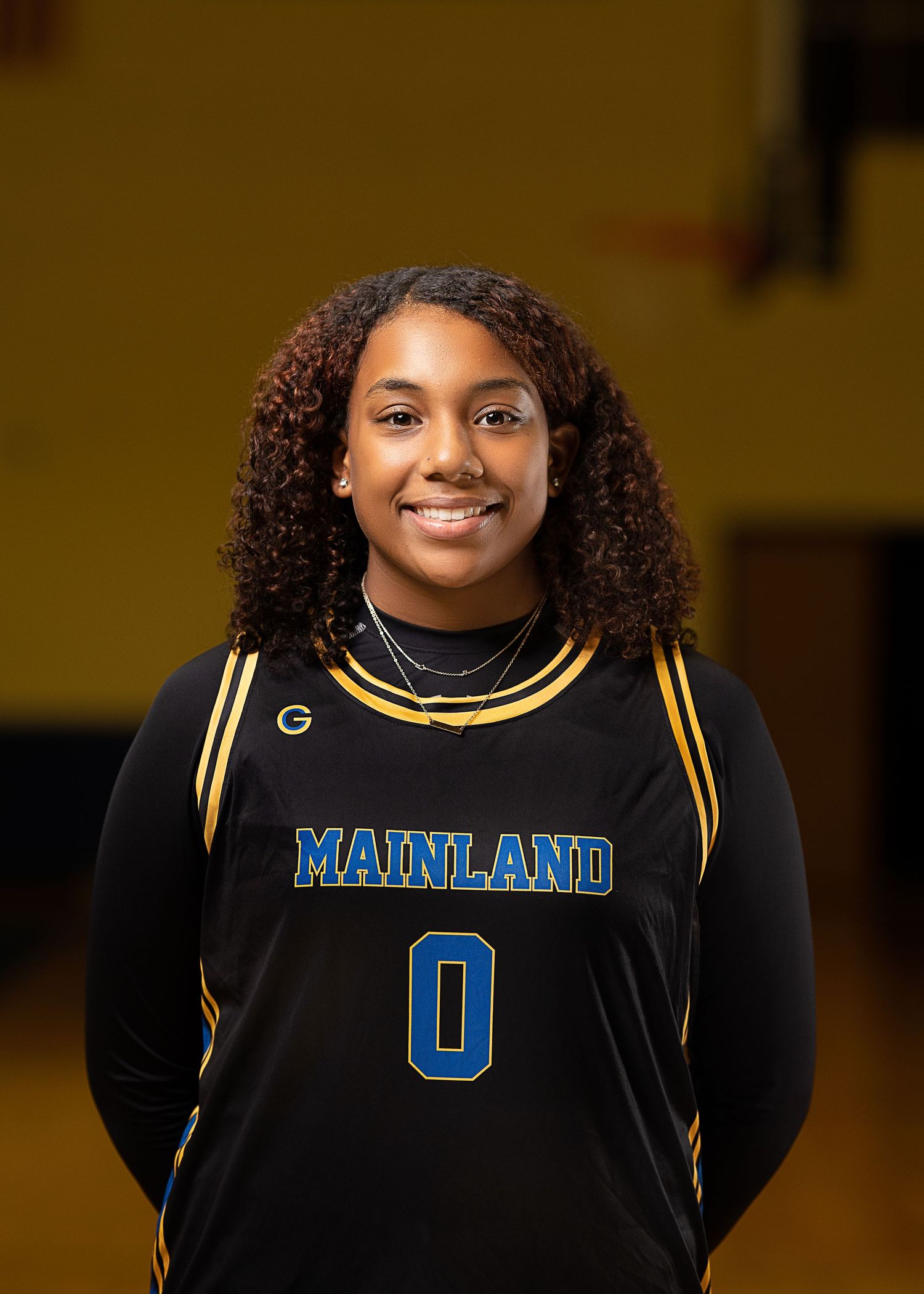 Basketball player wearing a black Mainland jersey number 0 poses for team photo.