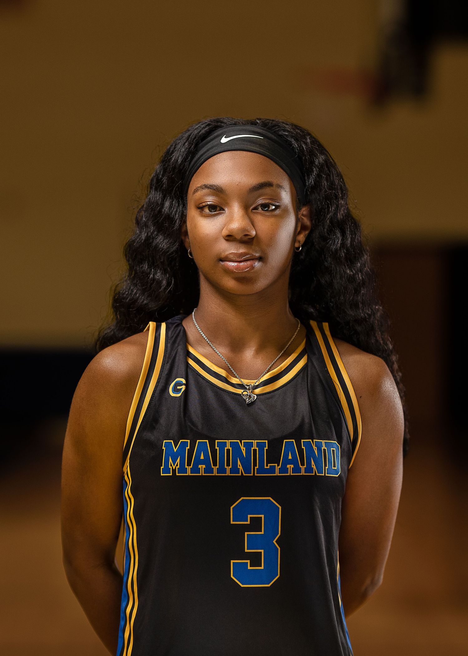 Basketball player wearing Mainland jersey number 3 poses for team photo.
