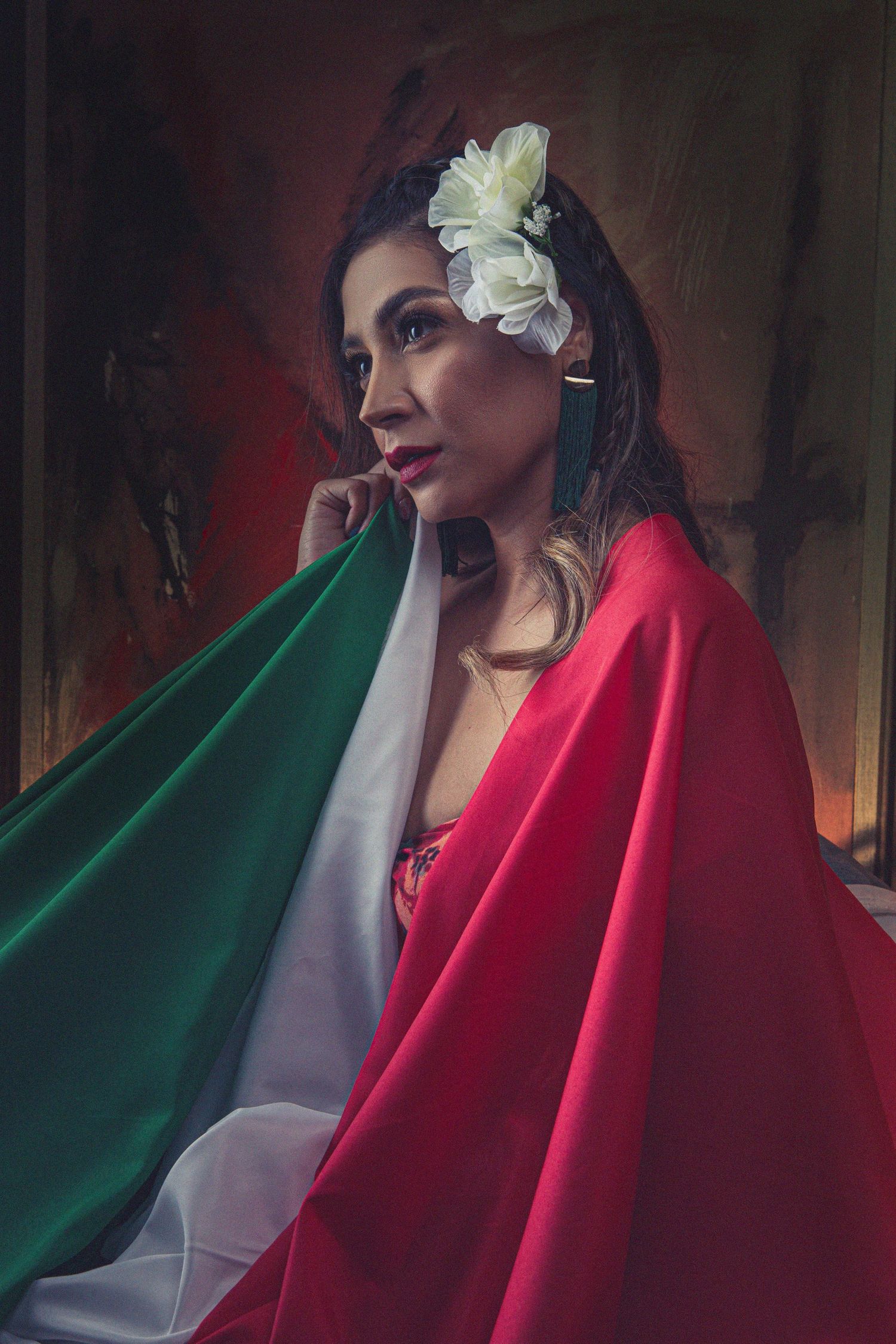 Portrait with Italian flag colors and white flower against dramatic red background.