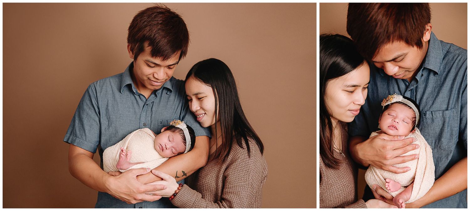 mom and dad together holding and looking at their baby