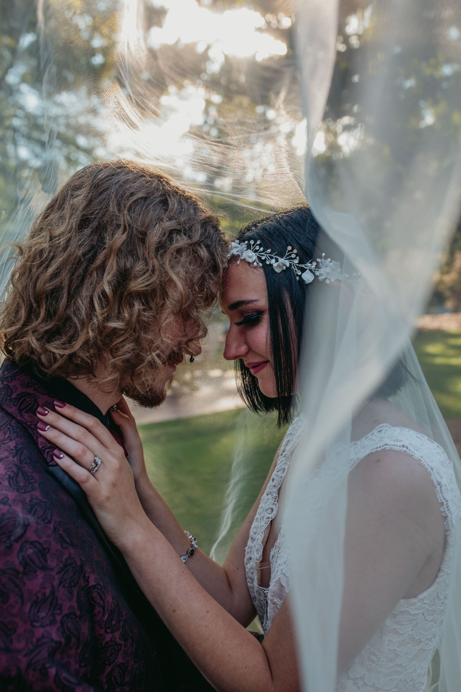 A couple shares an intimate moment beneath the bride's veil