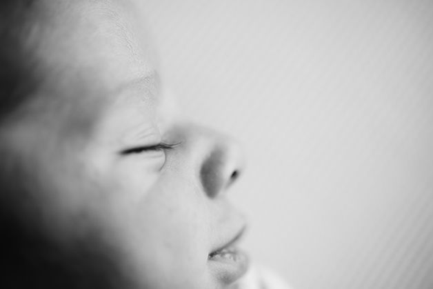 Artistic macro shot of sleeping baby's facial features in black and white.