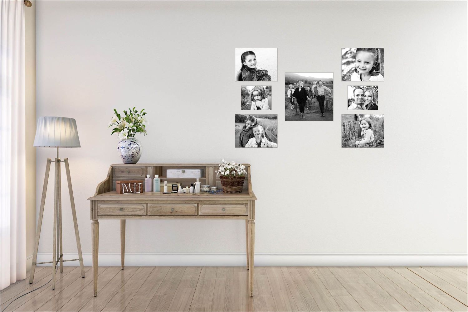 Modern interior with wooden writing desk, floor lamp and black and white photos on wall.