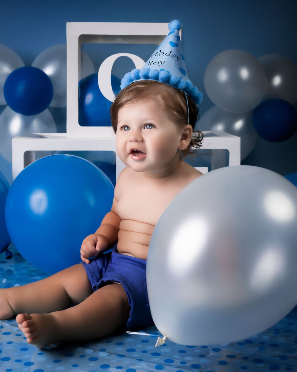 Blue and silver balloon setup for birthday photo session.