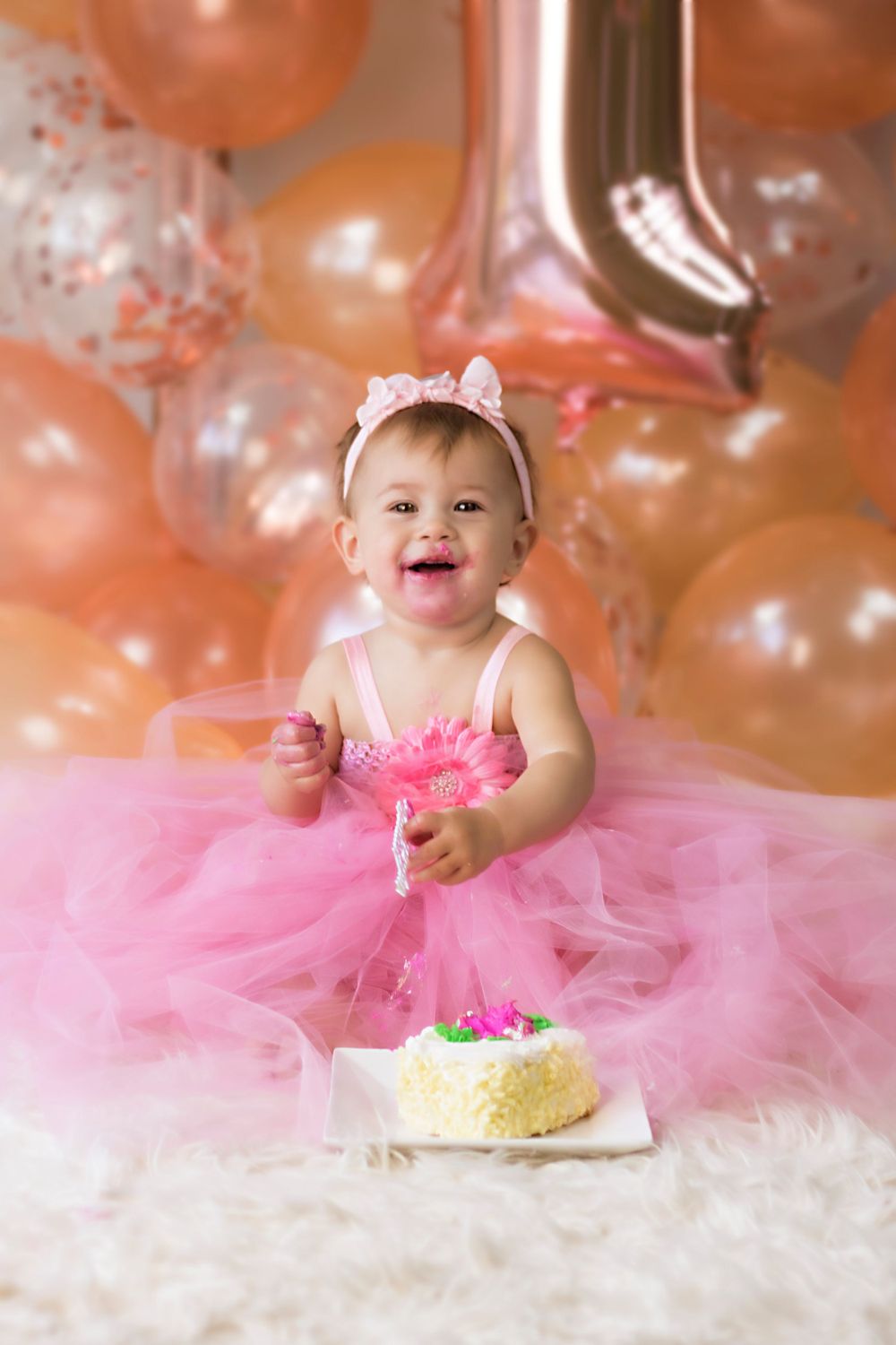 Cake smash photo session with pink tulle dress and balloons.