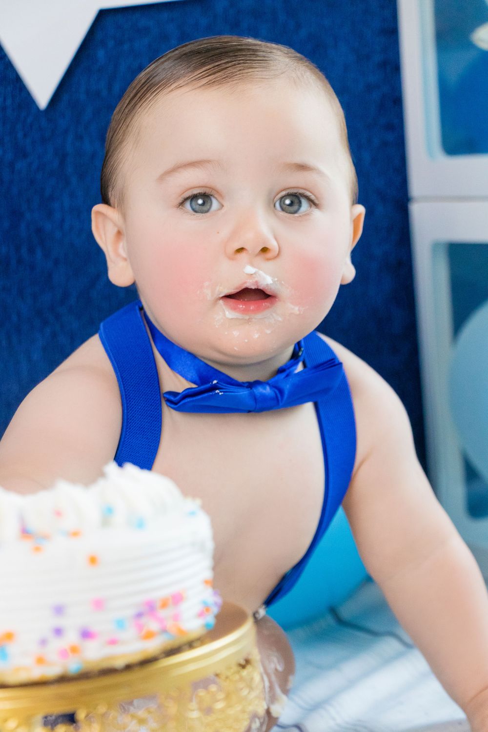 Birthday celebration with blue bow tie and white frosted cake.