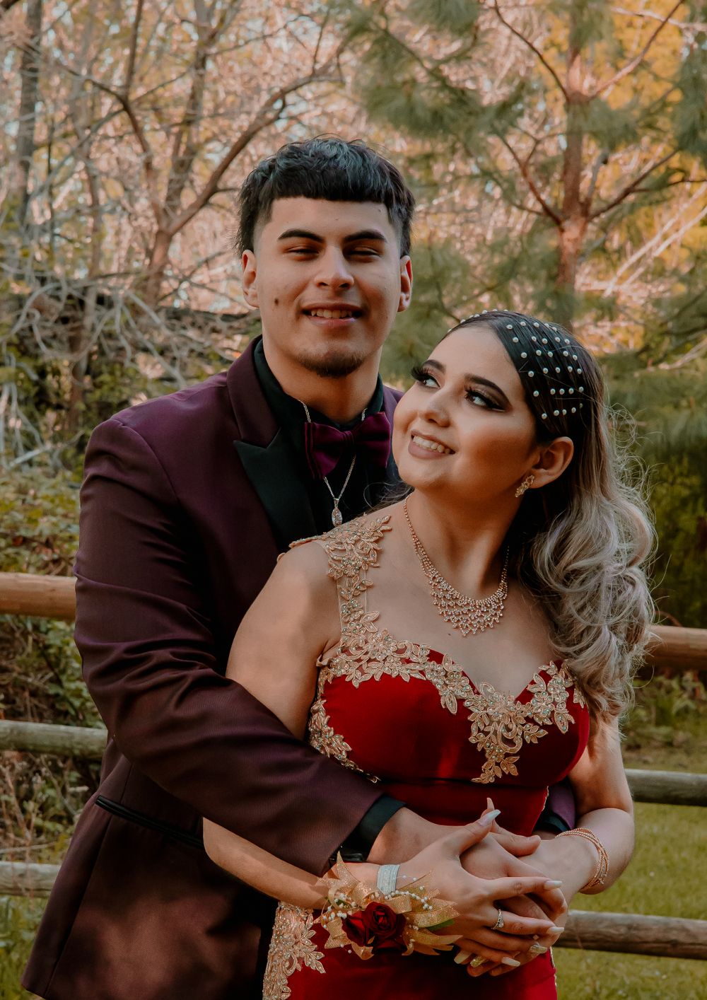 Romantic autumn photoshoot with couple in formal attire by rustic fence.