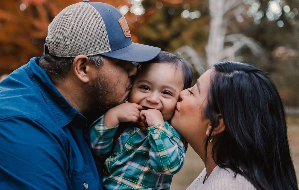 Family sharing intimate moment during autumn outdoor photoshoot.
