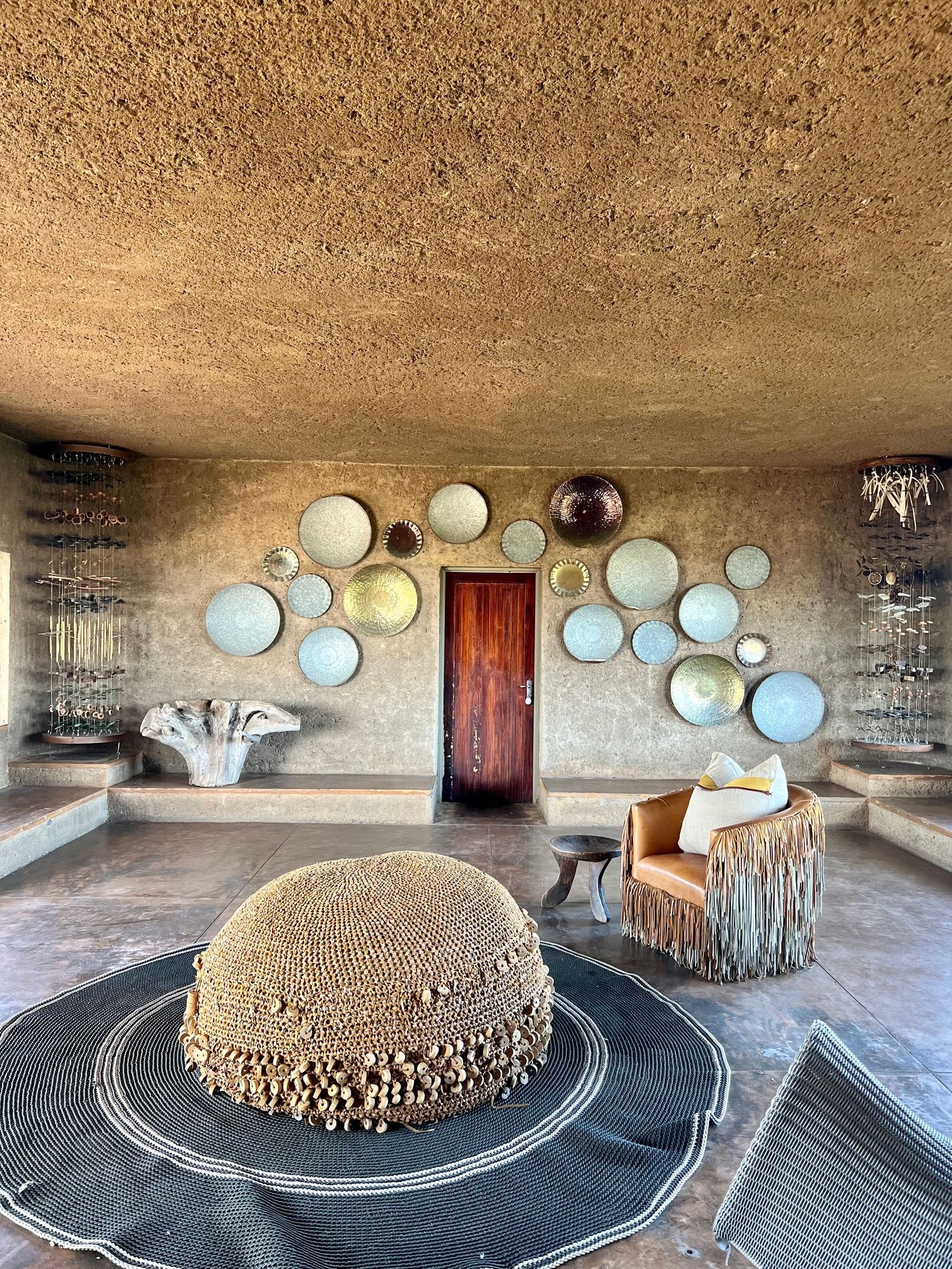 Circular room with decorative plates mounted on walls and central display platform.