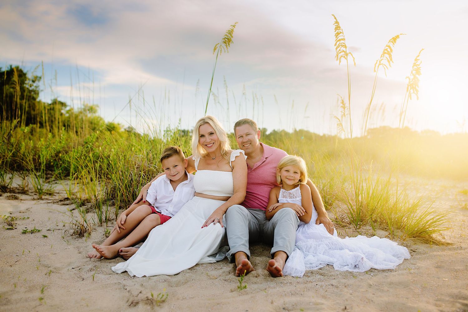 Beach family photography session at sunset with warm golden lighting.