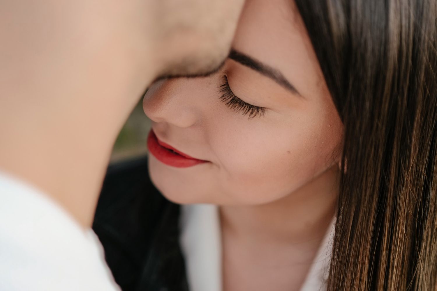 Intimate close-up portrait showing gentle expressions and red lipstick.