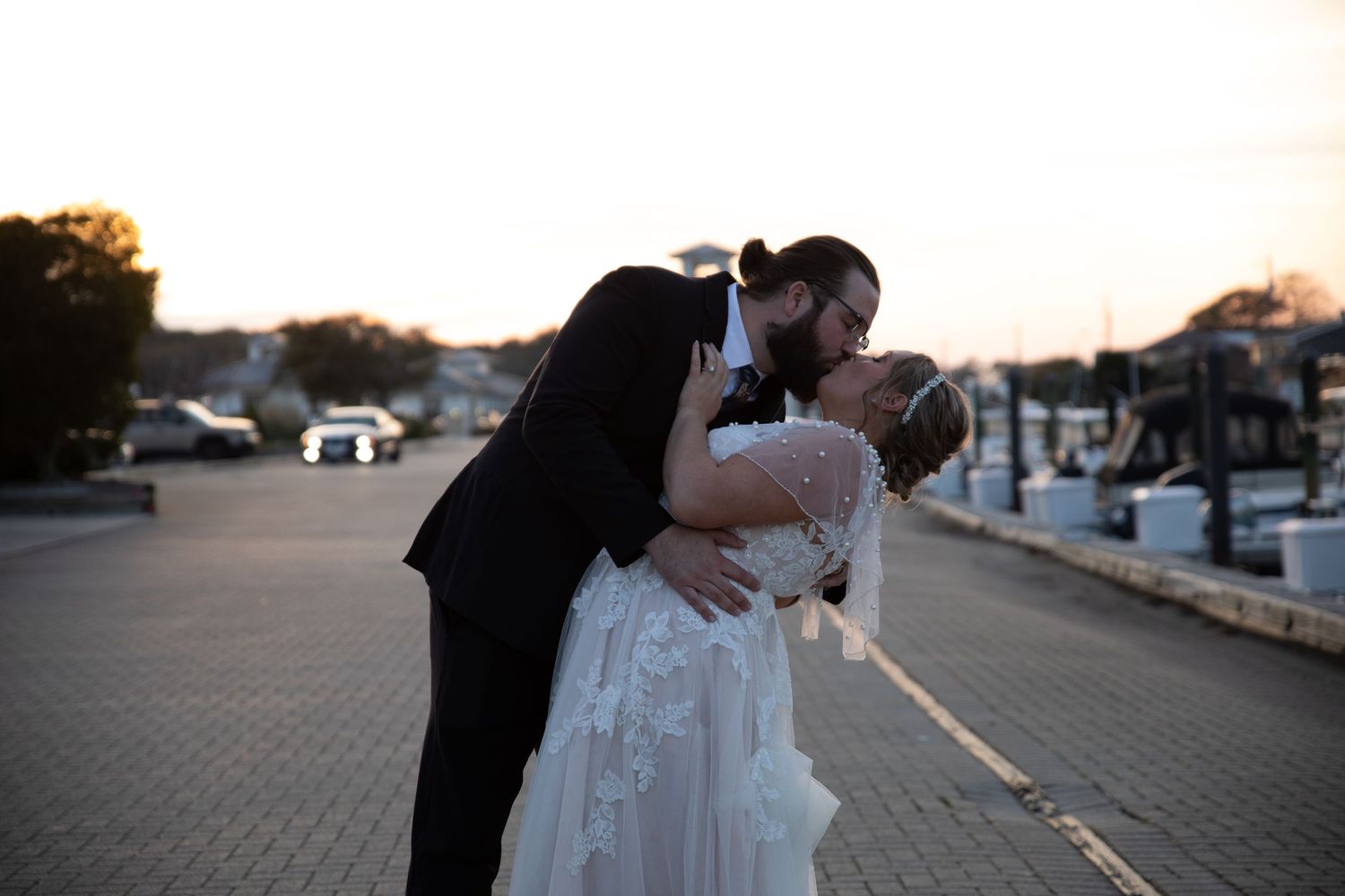 Intimate wedding couple moment captured during sunset at a waterfront location.