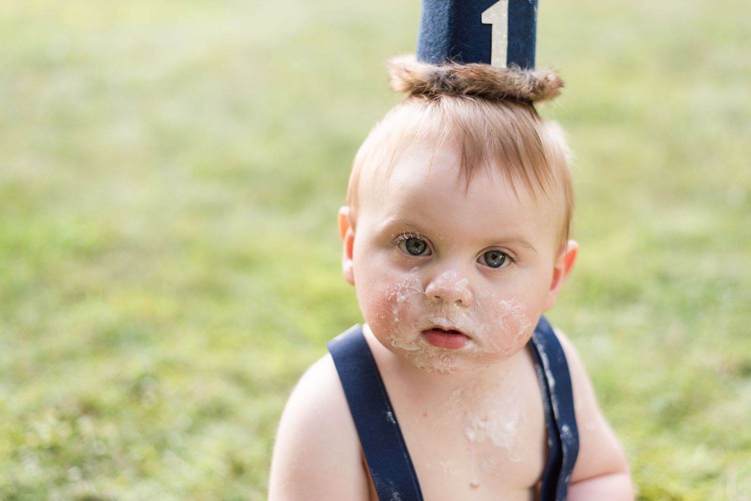 Baby with cake all over his face for first birthday in Pittsburgh, Pennsylvania