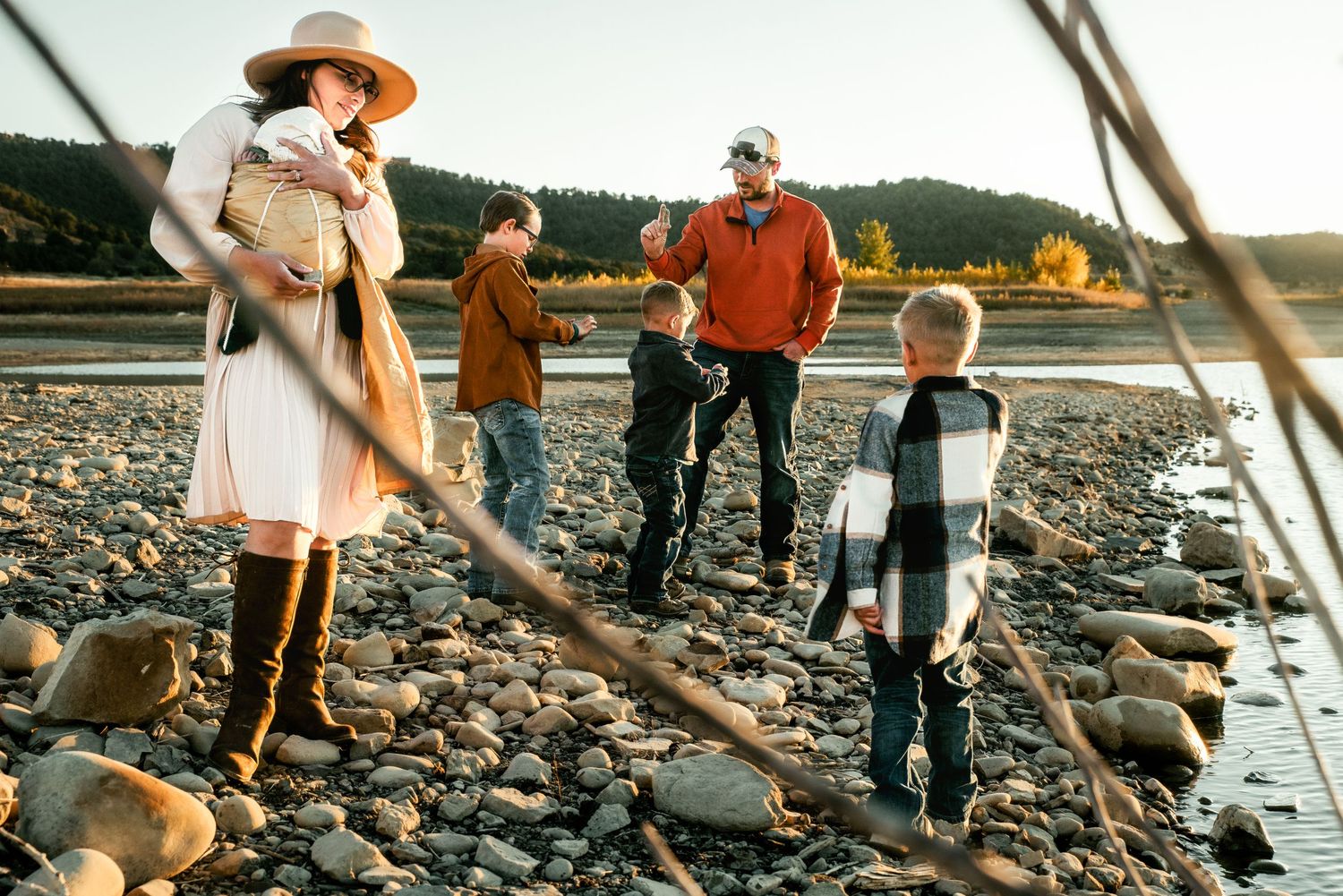 A young family exploring the beach at sunset.