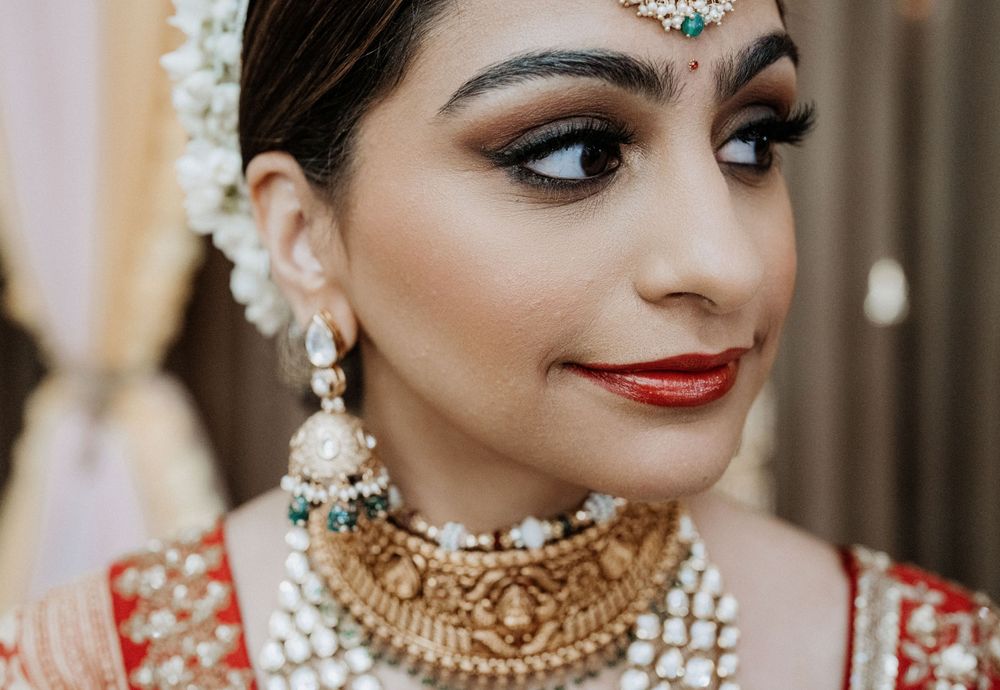 Close-up of traditional Indian bridal jewelry and makeup with emphasis on ornate necklace and tikka.