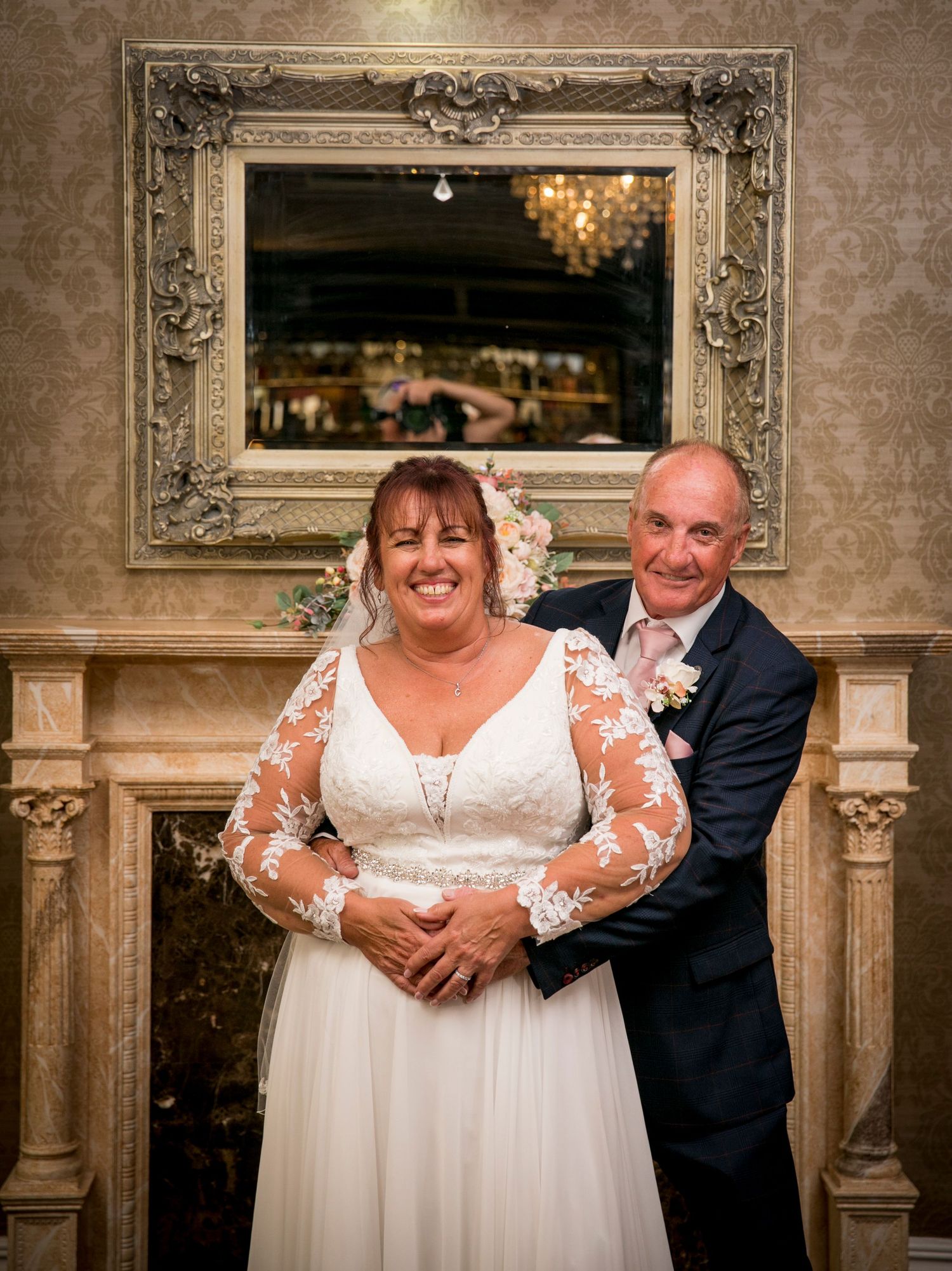 Romantic wedding portraits in an elegant room with ornate gold frames and wallpaper.