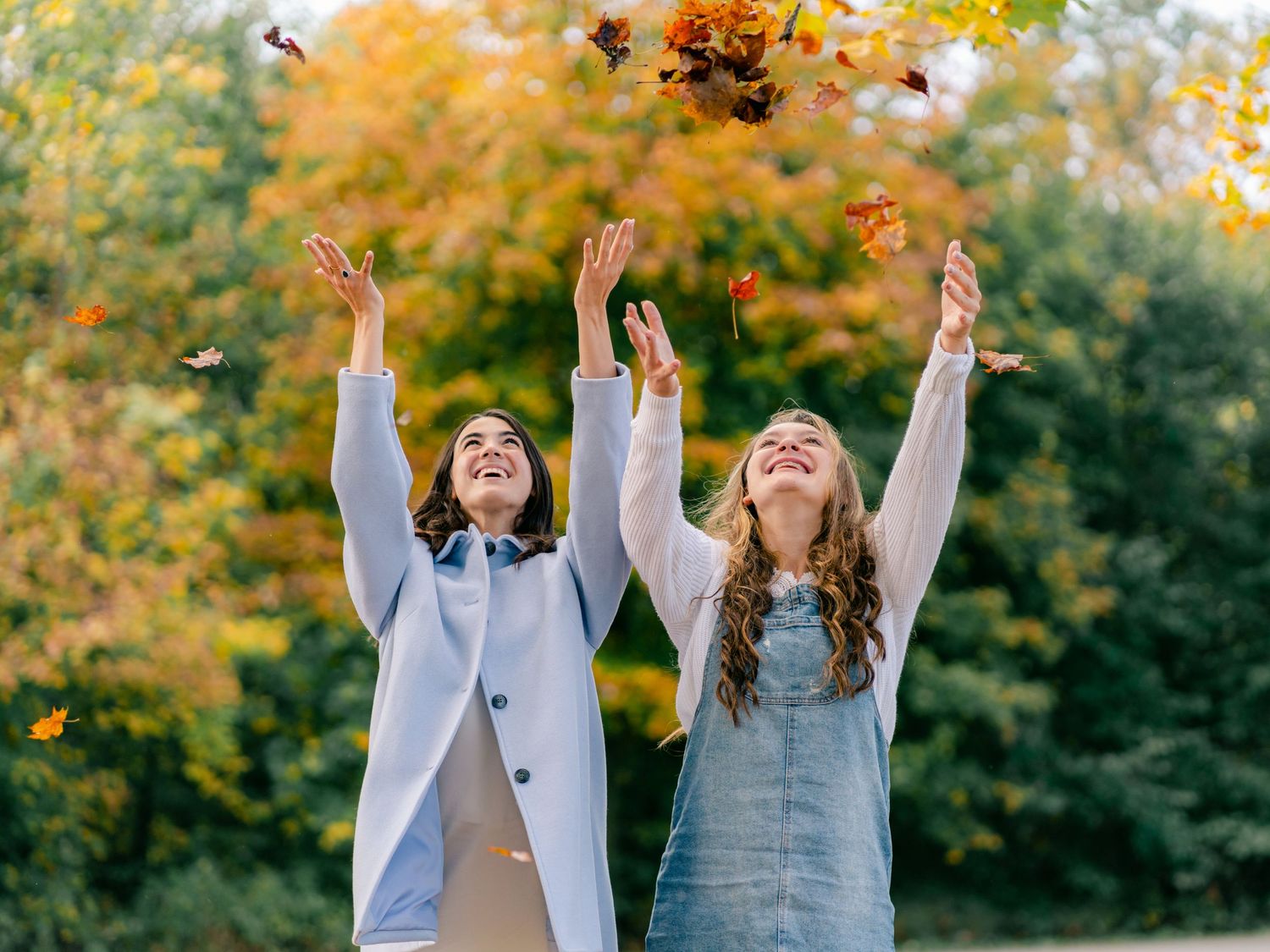 girls tossing leaves
