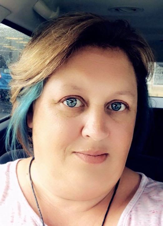 Close up selfie of a person with blue-tinted blonde hair in a car.