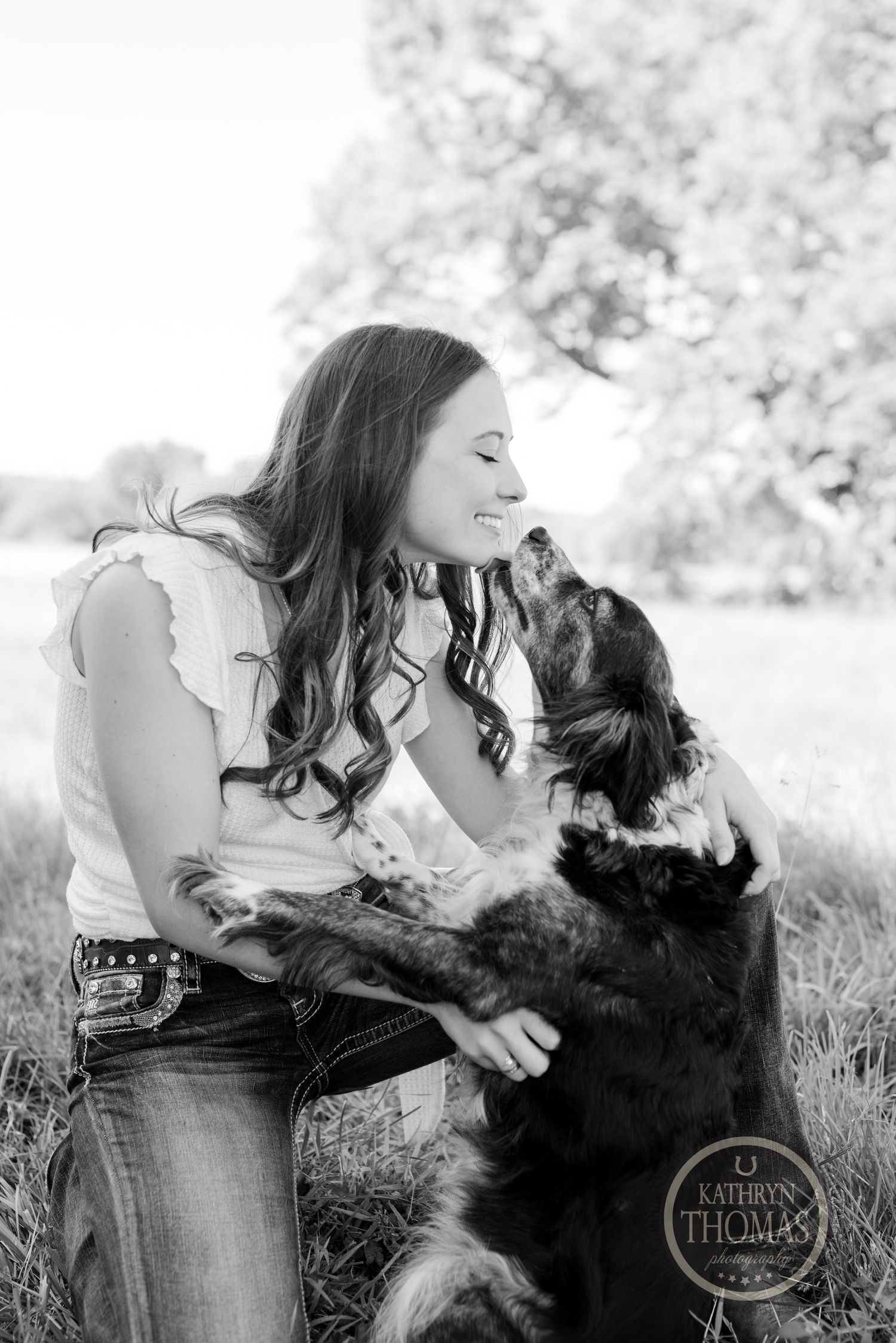 Black and white candid moment between person and dog in natural setting.