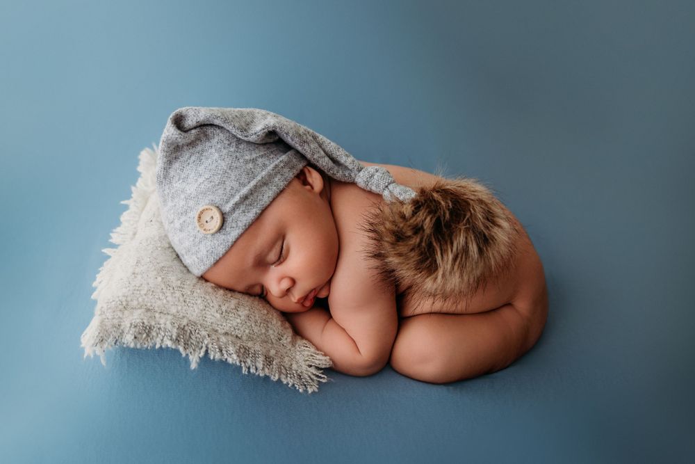 newborn boy blue sleepy hat pose studio table top bean bag session photographer WNY East Aurora Buffalo local