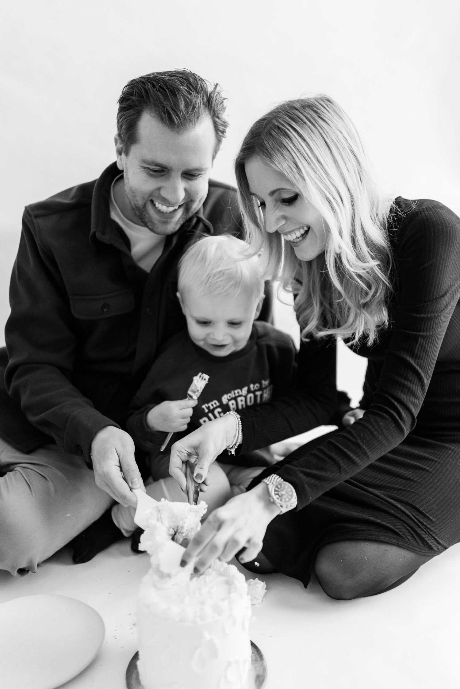 Black and white family moment celebrating with cake.