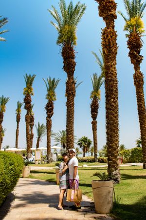Couple looking up at the sky surrounded by palm trees near the Dead Sea in Israel—captured by Michelle Baum Photography.