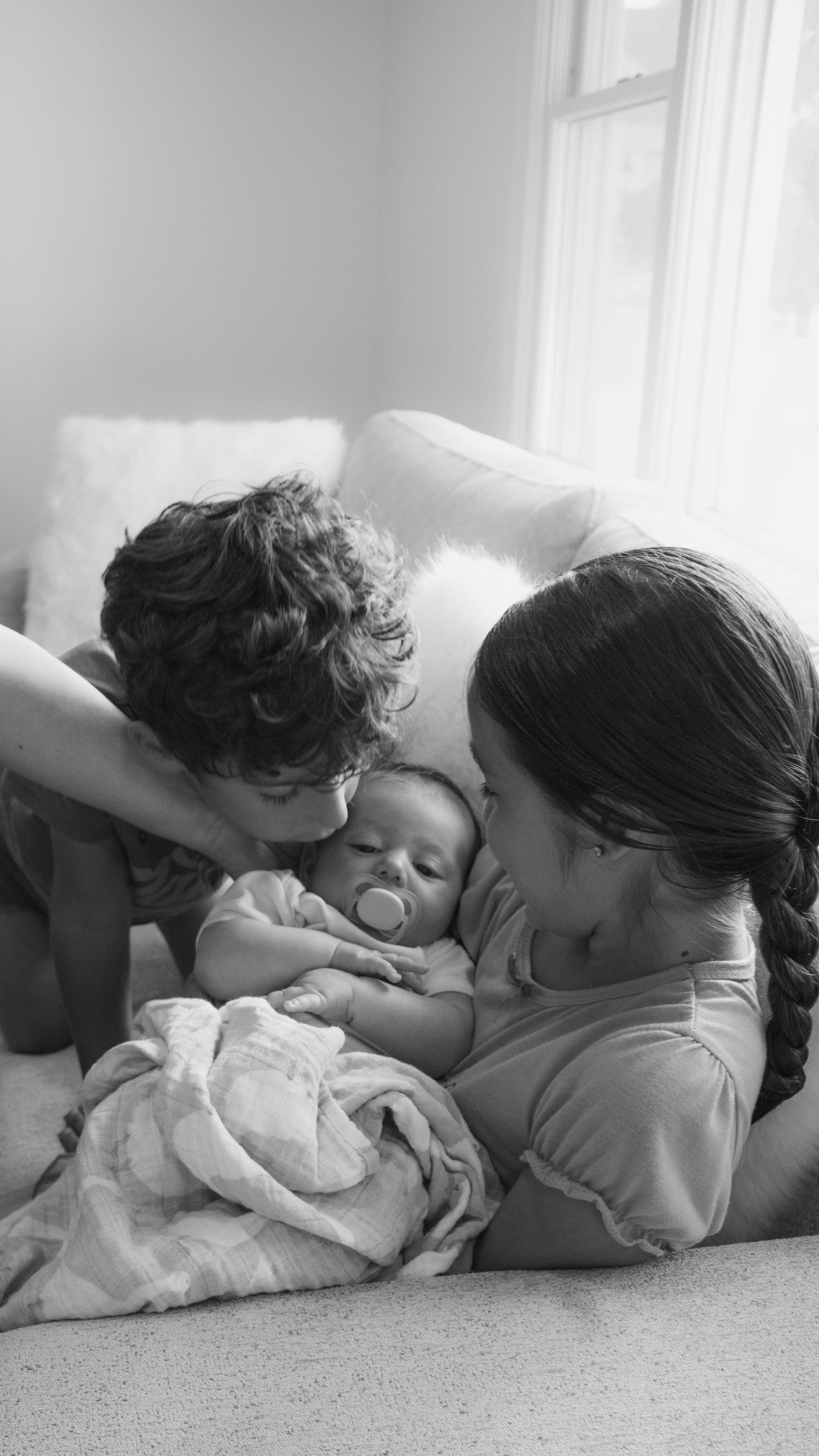 Heartwarming family portrait in Oakhurst, NJ as older siblings welcome their new baby—captured by Michelle Baum Photography.