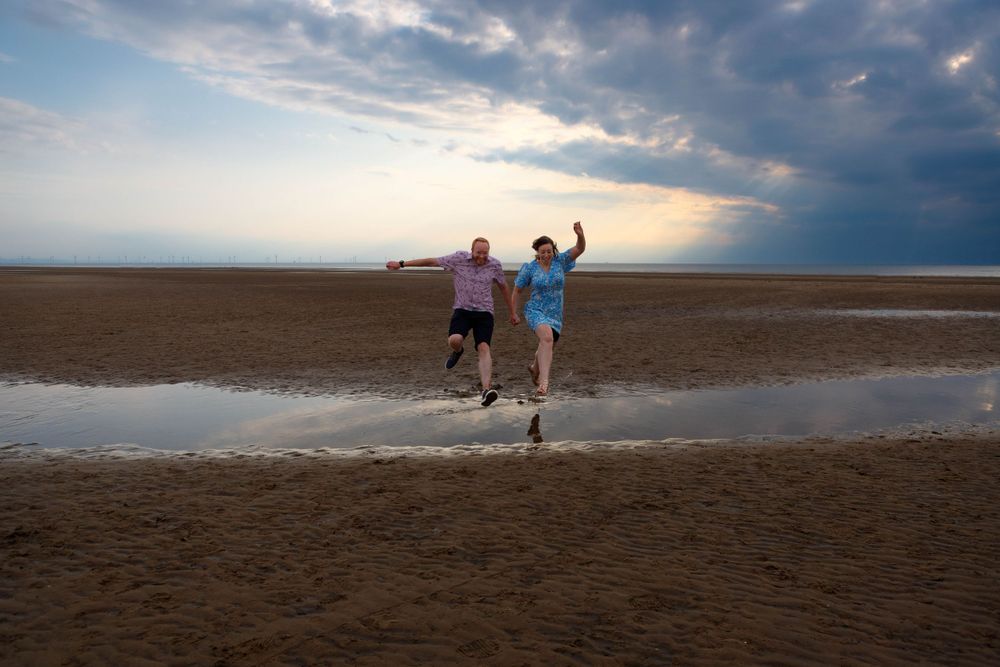 "couple jumping puddles pre wed shoot formby"