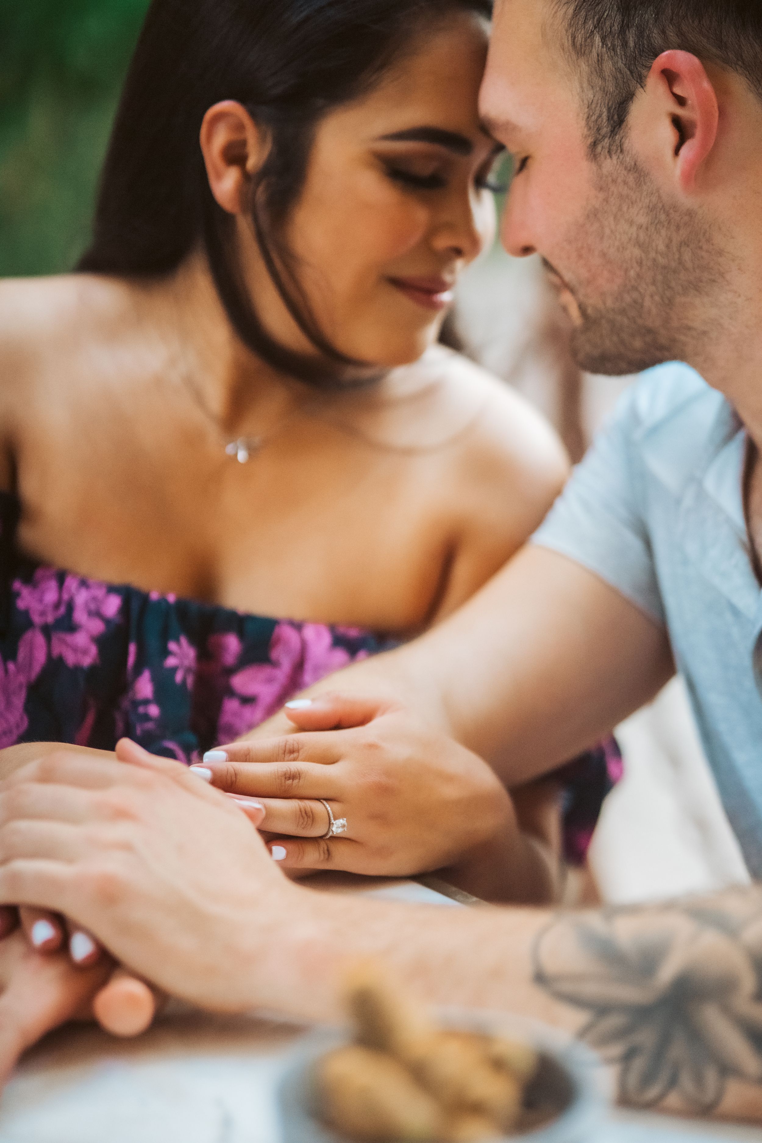 Romantic close-up of couple sharing intimate moment with ring visible.