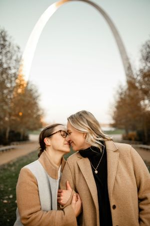 A romantic autumn sunset moment between two people wearing camel coats.